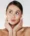 A image of a woman's face holding her face.